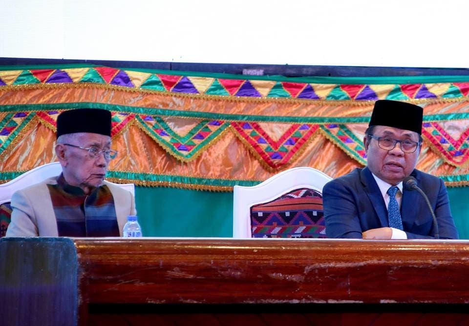 Two officials seated at a carved wooden rostrum during the first session of the Bangsamoro Transition Authority.