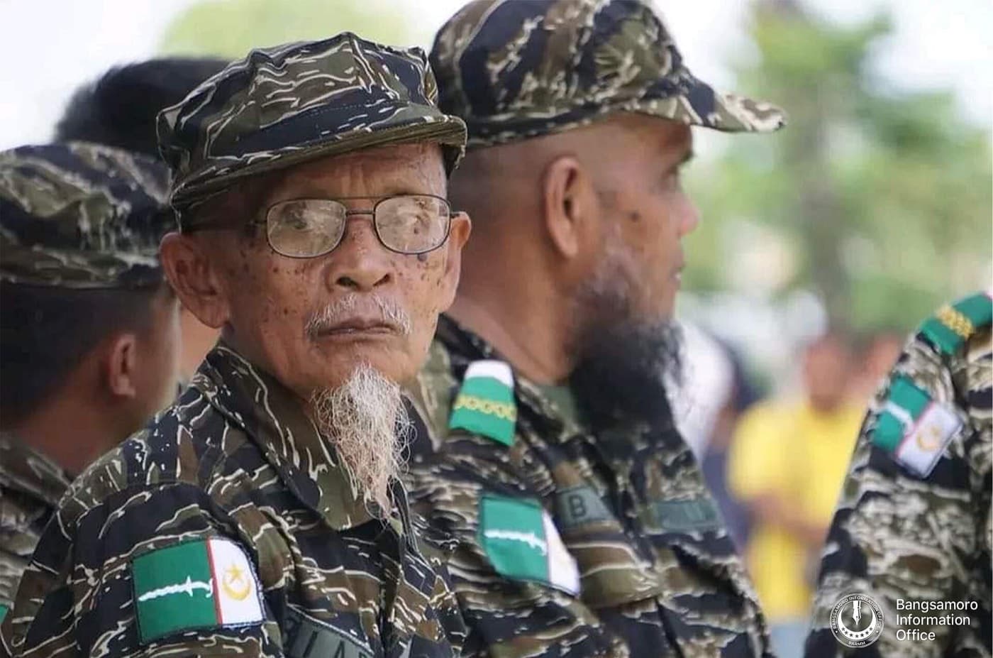 Two older fighters of the Moro Islamic Liberation Front in camouflage, sleeve patches bearing the front's emblem.